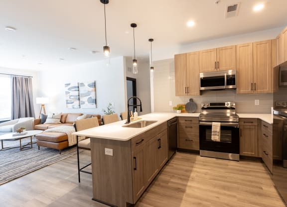 a kitchen with a large center island with a breakfast bar and a living room with a couch
