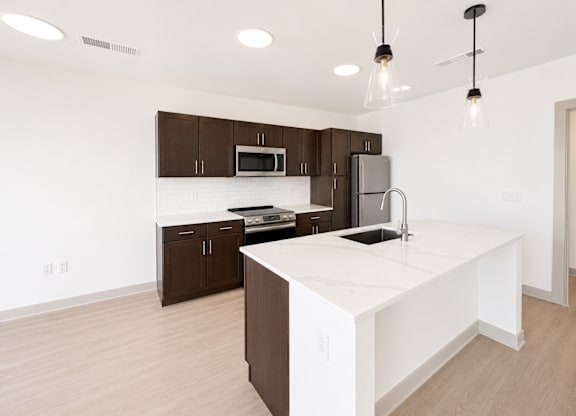 A kitchen with brown cabinets and a white island.