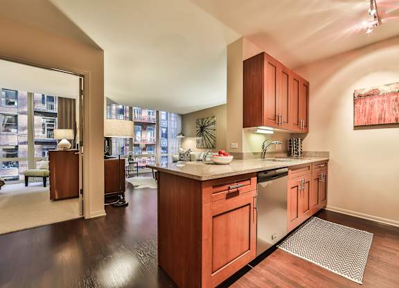 A kitchen with wooden cabinets and a stainless steel refrigerator.