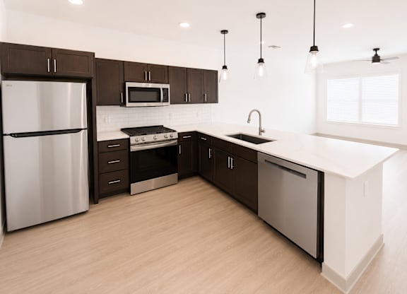 A modern kitchen with dark brown cabinets and a white countertop.