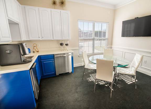 A kitchen with blue cabinets and white walls.