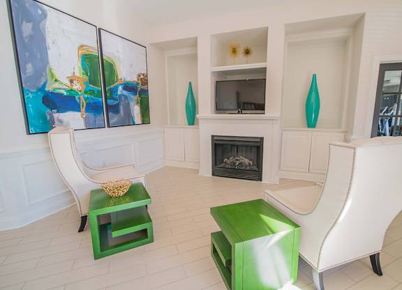 A living room with a fireplace and a painting on the wall.