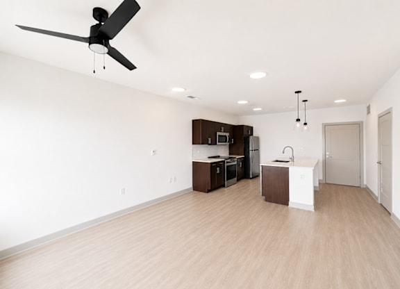 A room with a ceiling fan and wooden flooring.
