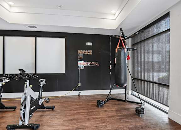 Markethaus 3700 Athletic Club Boxing Bag Free Standing A gym with a punching bag, exercise bikes