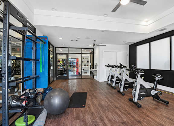 Markethaus 3700 Fitness Studio A gym with a variety of equipment including a stationary bike, a medicine ball, and a weight rack.