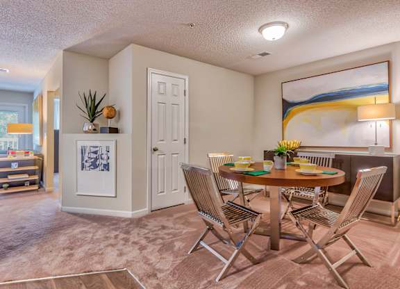 A dining room with a table set for four.