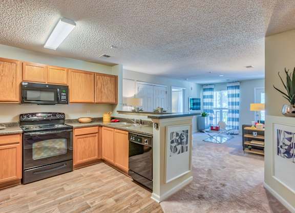A kitchen with wooden cabinets and a black stove top oven.