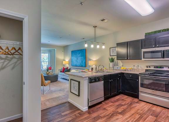 A kitchen with black cabinets and stainless steel appliances.