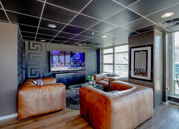 A living room with a brown leather sofa and a television.