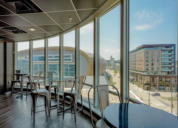 A room with a table and chairs with a view of the city.
