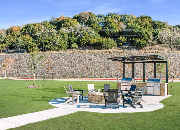 a patio with a table and chairs and a fire pit