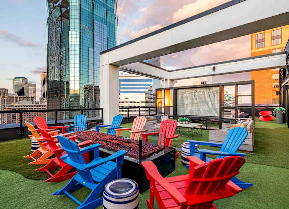 a terrace with red and blue chairs and a table