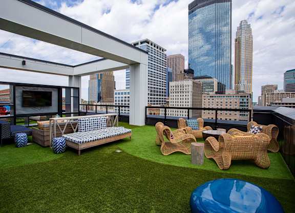 a roof top patio with furniture and a view of the city