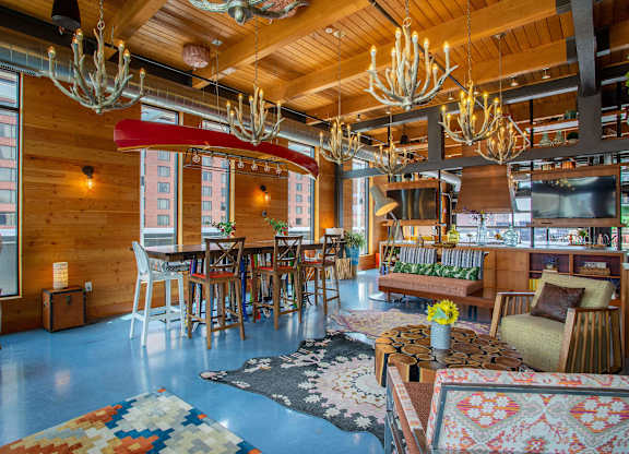 a living room and dining room with wooden ceilings and chandeliers