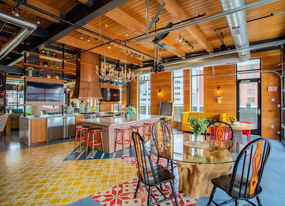 the kitchen and dining area of a loft with a table and chairs