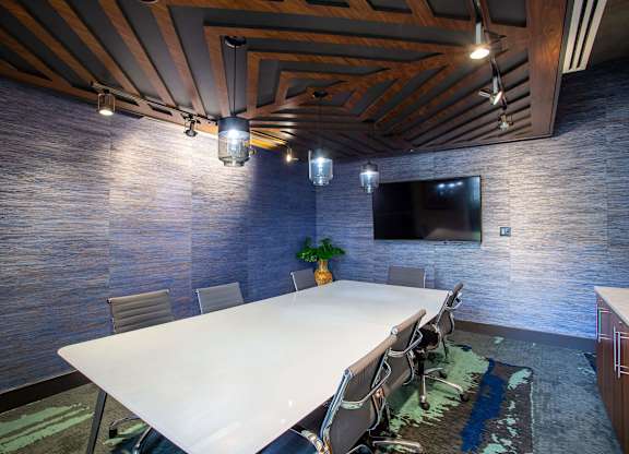 a conference room with a white table and a tv