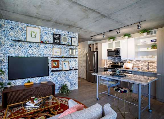 a kitchen and living room with blue and white tiles on the wall