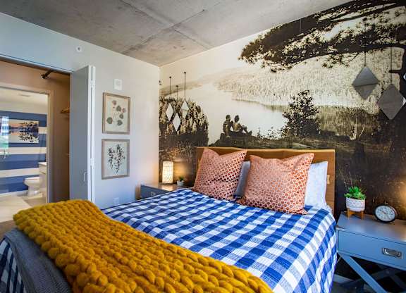 a bedroom with a bed and a mural on the wall