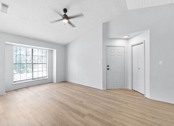 A room with a ceiling fan and two doors.