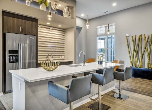 a kitchen with a large island and a stainless steel refrigerator