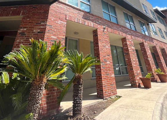 a brick building with palm trees in front of it