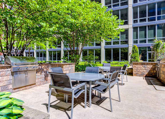 a patio with a table and chairs in front of a building