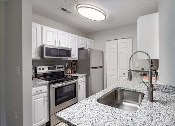 A kitchen with granite countertops and stainless steel appliances.