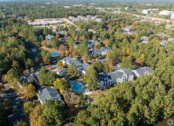 An aerial view of a residential area with houses surrounded by trees.