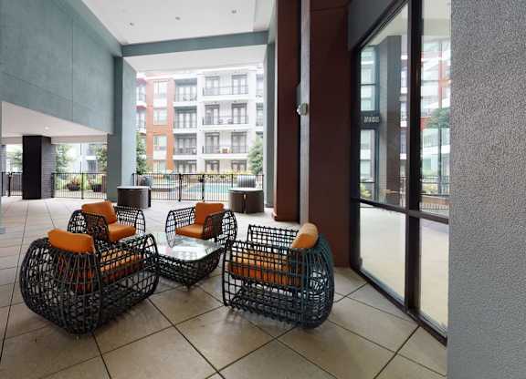 Two black wire baskets with orange cushions sit on a tiled floor.