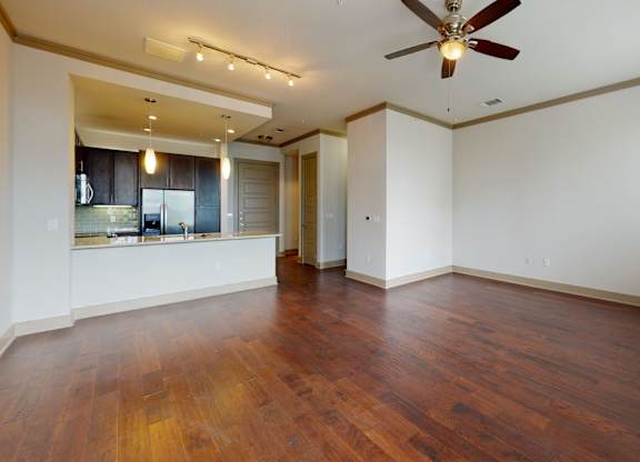 A room with a ceiling fan and wooden floors.