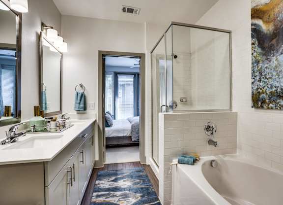 Spa inspired bathroom with shower and tub combo and dual sink vanity at at Midway Urban Village Luxury Townhomes and loft apartments in Farmers Branch, Texas near North Dallas. Luxury North Dallas Tow