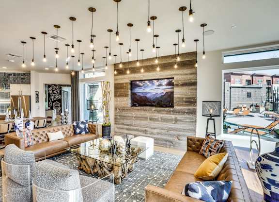 A modern living room with a large couch and a television mounted on the wall.