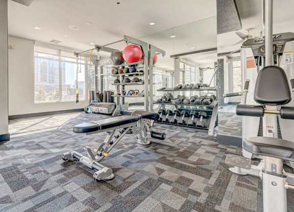 A gym with a variety of equipment including weights and a rowing machine.
