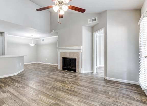 A living room with a fireplace and wood flooring.