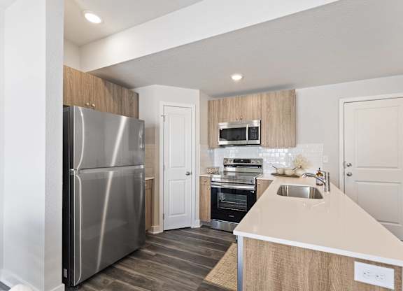 A modern kitchen with a stainless steel refrigerator and a wooden island.