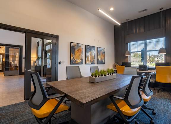 A conference room with a long table and chairs.