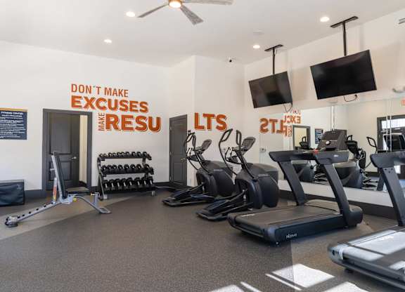 A gym with a sign that says "Don't make excuses when you're in the gym.".