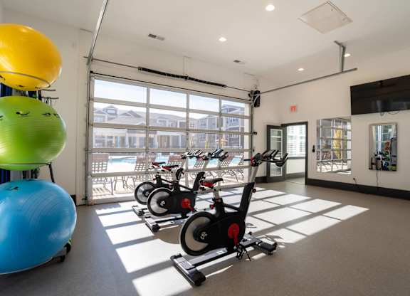 A gym with exercise equipment and a television.