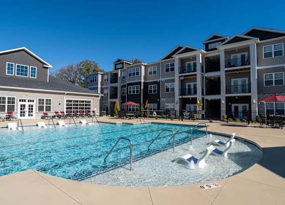 A swimming pool with a slide and a building in the background.