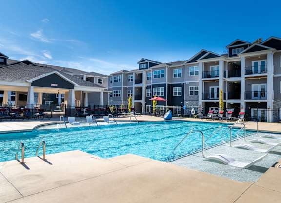 A large swimming pool in front of apartment buildings.