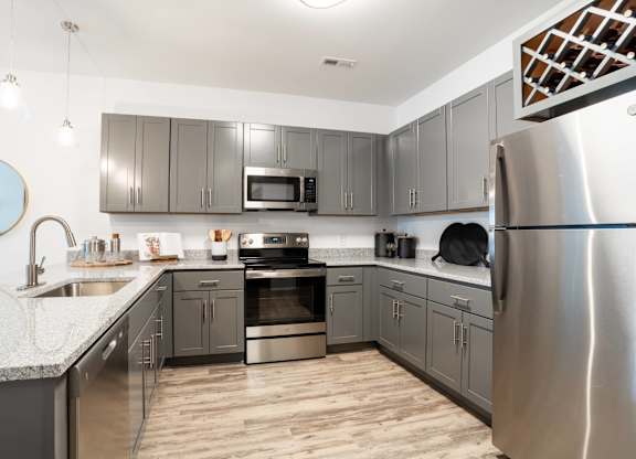 A modern kitchen with stainless steel appliances and wooden floors.