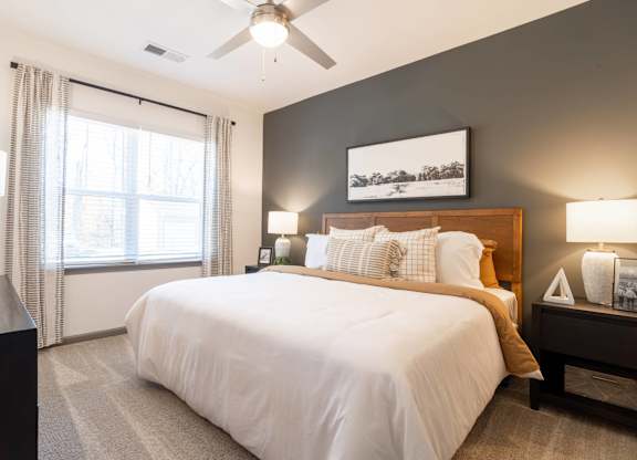 A bedroom with a large bed and a ceiling fan.