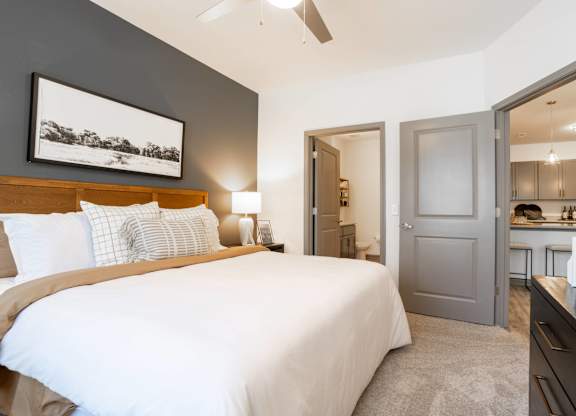A bedroom with a large bed and a painting on the wall.