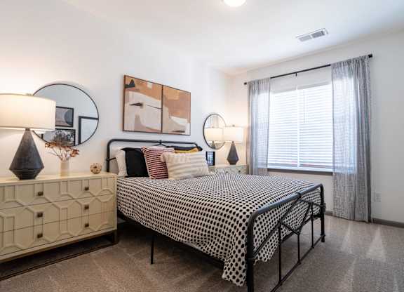A bedroom with a bed, nightstand, and two lamps.