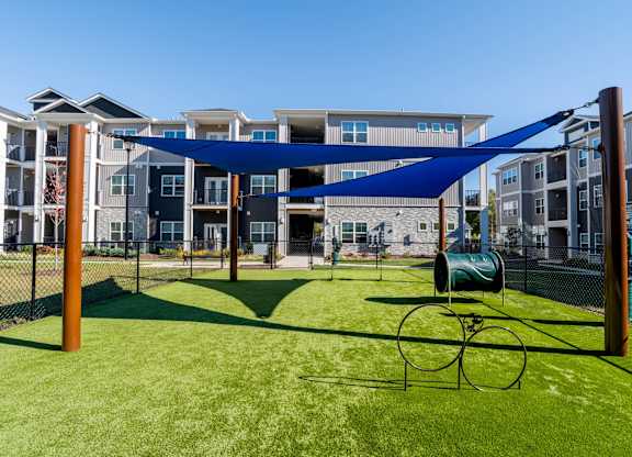A playground with a blue canopy and a green slide.