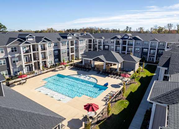 A large swimming pool surrounded by apartment buildings.
