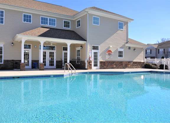 A large house with a pool in front.