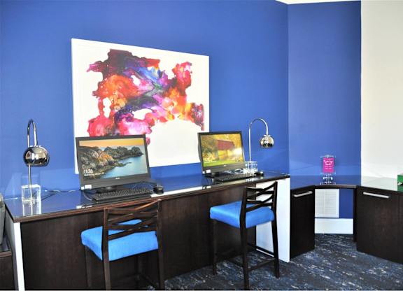 A room with a blue wall and a painting on it.