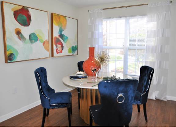 A dining room with a white table and blue chairs.