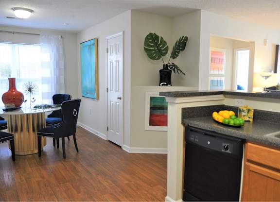 A kitchen with a black dishwasher and a black chair.